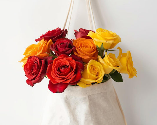 Bouquet of red and yellow roses in a glass vase against a white background